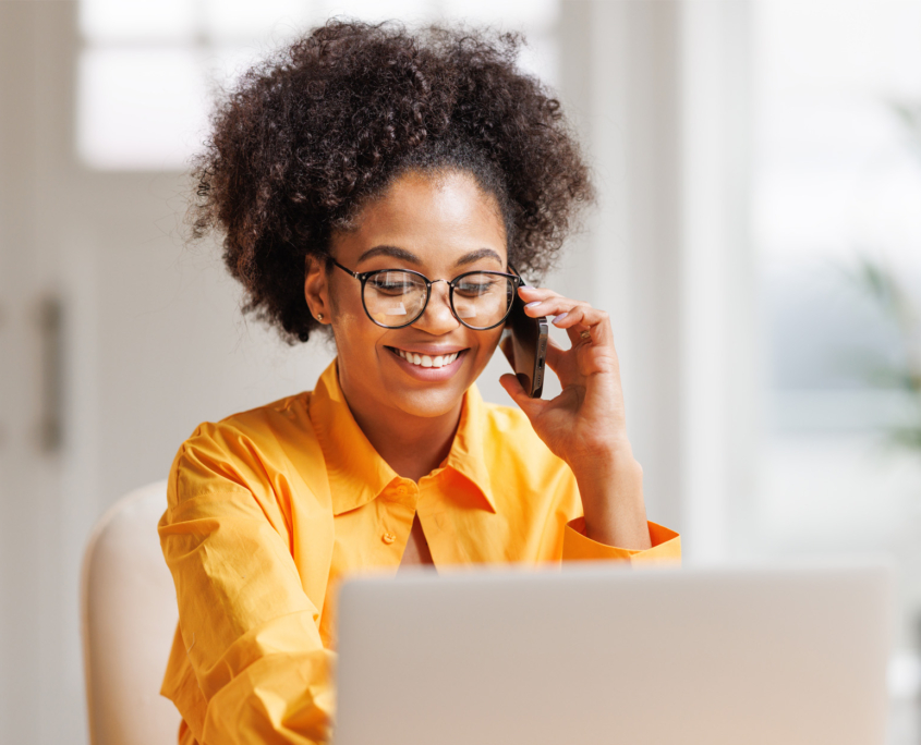 person orange shirt at laptop