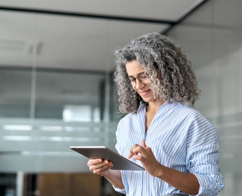 woman striped shirt in office on tablet