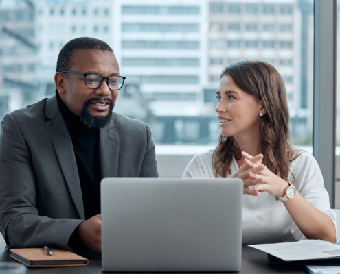 Cropped shot of two corporate business colleagues having a meeting around the table in the boardroom