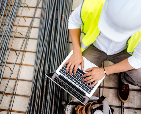 Top down view of an engineer using laptop on construction site